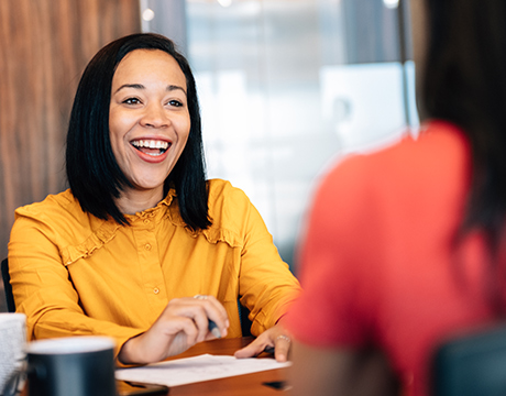 a woman smiling and discussing a report